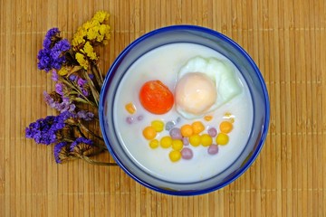 Thai rice balls in sweet coconut milk with salted egg yolk and sweet boiled egg, Authentic Thai dessert.