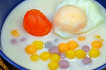 Thai rice balls in sweet coconut milk with salted egg yolk and sweet boiled egg, Authentic Thai dessert.