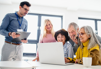 Group of senior people attending computer and technology education class.