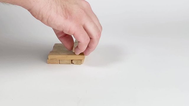 Man stacking more Jenga Blocks in Slow Motion