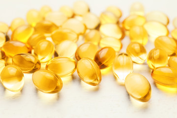 Fish oil capsules on white table