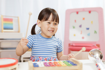 toddler girl play xylophone at home for homeschooling