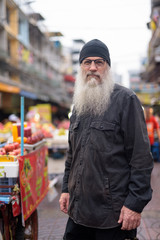 Mature bearded tourist man with eyeglasses in Chinatown