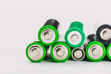 many new and used alkaline the positive ends of battery cells. type AA on a light background.