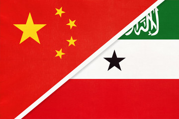 China or PRC vs Somaliland national flag from textile. Relationship between Asian and African countries.
