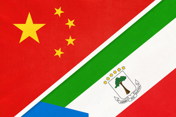 China or PRC vs Equatorial Guinea national flag from textile. Relationship between Asian and African countries.