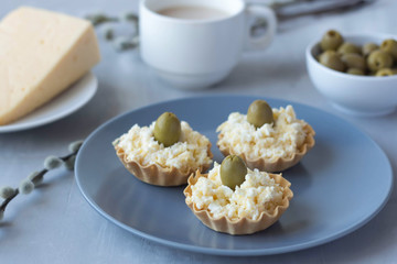 cheese snack with olives in baskets of dough on a plate