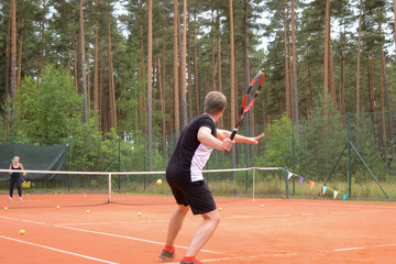 back view of a male tennis player with a racket waiting for a pass from the opponent