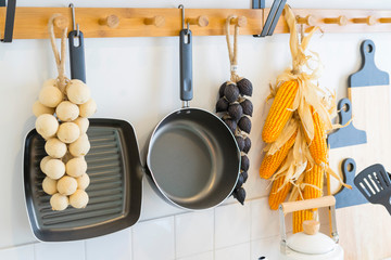 Arrangement of dry food products, spices and ceramics kitchen equipment hanging on country shelves in rustic home kitchen.