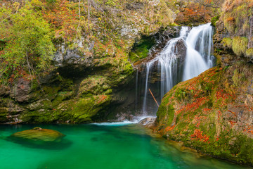 waterfall and green lake in autumn