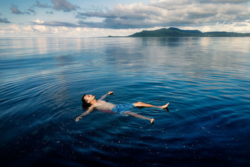 a man floating on water at karimunjawa island, Indonesia