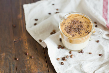 Iced Dalgona Coffee with chocolate powder in a glass cup. Trendy fluffy creamy whipped coffee.