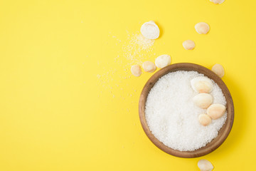 sea salt and a stiff body brush on a yellow background. home skin care for cellulite. concept skin care in spring, home Spa, care products.