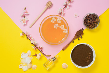 natural organic ingredients-sea salt, coffee scrub, honey and a hard body brush on a yellow background. home skin care for cellulite. concept of skin care, home Spa. the view from the top.