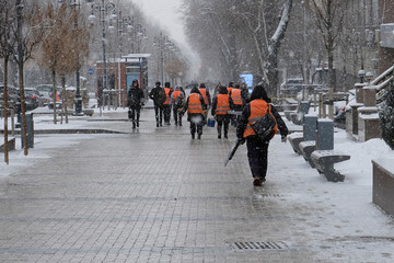 Janitors team are going to clean snow. Workers are going to remove snow in snowfall. Workers with...