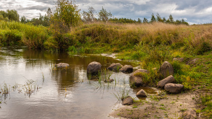 Autumn landscape with a river on a cloudy day