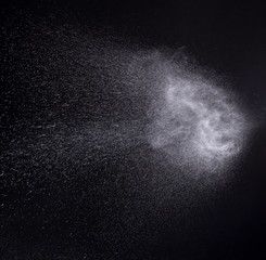 a spray of liquid in a black background.