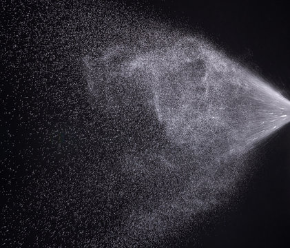 a spray of liquid in a black background.