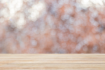 image of raindrops on glass with wooden board, bokeh soft defocused lights background. 