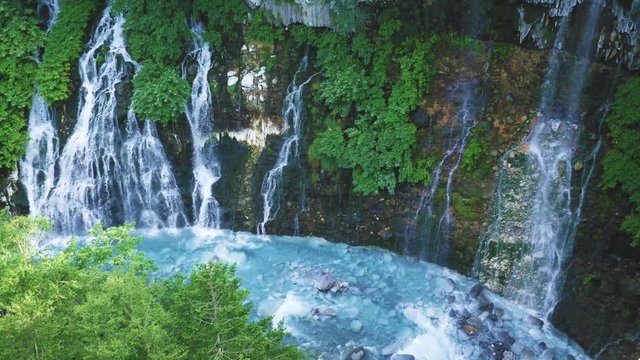 The natural wonder of Biei, Hokkaido - turquoise Shirahige waterfalls on a sunny summer day