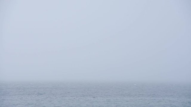 The beautiful, calm waves by Rathlin Island in Ireland before a storm - wide shot