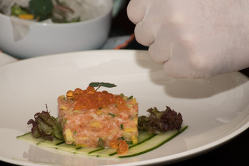 Chef is decorating salmon tartar