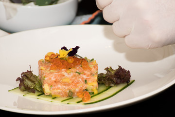 Chef is decorating salmon tartar