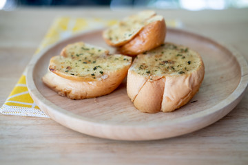 Wooden plate with delicious homemade garlic bread