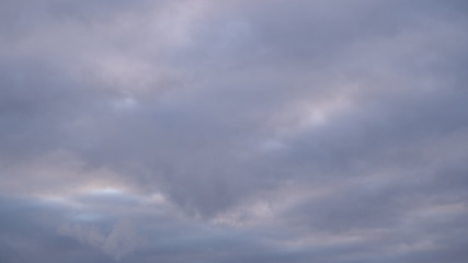 Fototapeta premium A beautiful evening blue sky at sunset with flaming bright light clouds. Warm evening.