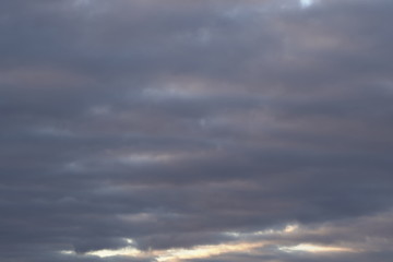 Obraz premium A beautiful evening blue sky at sunset with flaming bright light clouds. Warm evening.