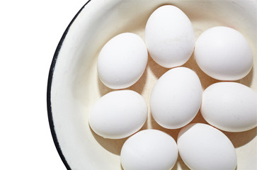 Boiled hen eggs in a metal enamel bowl isolated on white background. Top view