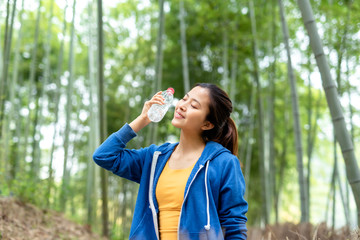A young Asian woman walking in the bamboo forest