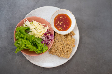 Crispy catfish spicy salad with sliced mango, shallot and lettuce