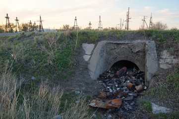 Culvert hole littered with household waste.