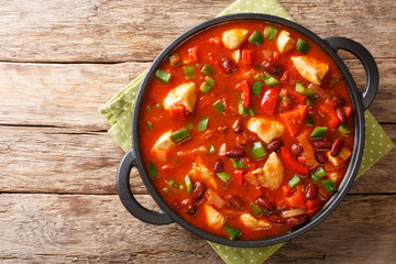 Thick tasty chicken stew with red beans in spicy chili sauce close-up in a pan. horizontall top view - obrazy, fototapety, plakaty