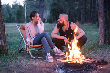 Couple enjoying in nature close to campfire