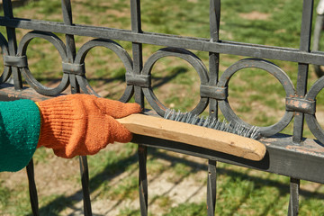 the master cleans the metal fence from rust
