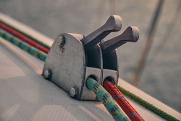 close up red and green rope in stopper of sailboat at sunset. Yachting concept and sea background.
