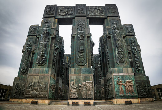 Wide angle dramatic moody image of Chronicles of Georgia sight with no tourists and resting bencehs around. Concept of history of Georgia. 2020