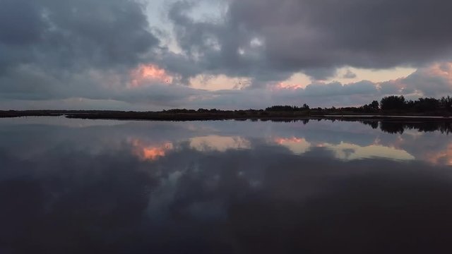 Early morning drone footage capture of sunrise over a lake.