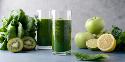 Green smoothie in  glass. Spinach, apple, kiwi, lemon, lime ingredients. Detox breakfast