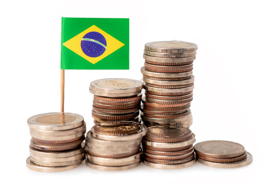 Stack of coins with Brazil flag on white background.