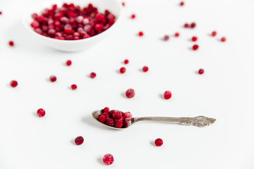 Frozen cranberries in the white plate.Fresh red berry cranberries.White background