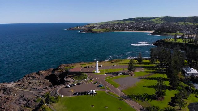 Kiama, a resort town in Australia. An aerial view of the picturesque rocky headland. A white lighthouse stands on the ocean.
