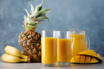 Mango smoothie with pineapple and banana in glasses. Fresh breakfast, detox drink