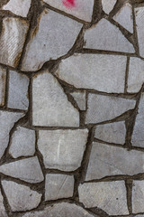 Stone wall, combined with a cement wall. Figure gray modern design style decorative uneven cracking real marble stone surface of the wall with cement