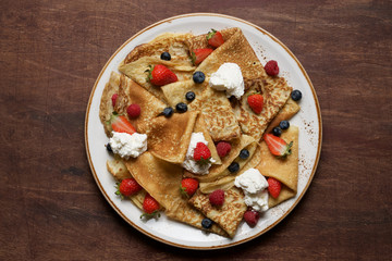 Thin crepes  with fresh berries and ricotta. Traditional Russian, Ukrainian or French pancakes