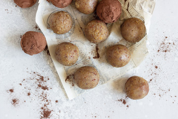 Healthy vegetarian energy balls with chickpea, peanut butter, raisin and cocoa powder. Homemade paleo truffles. Light grey background, selective focus. Top view.