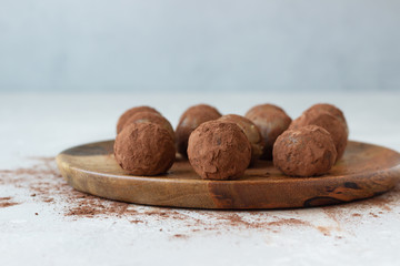 Homemade raw energy balls with chickpea, peanut butter, raisin and cocoa powder, light grey background. Selective focus. Vegan and vegetarian snack.