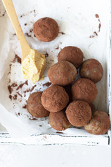 Raw vegan healthy dessert or energy balls with peanut butter, wooden tray. Selective focus. Top view.